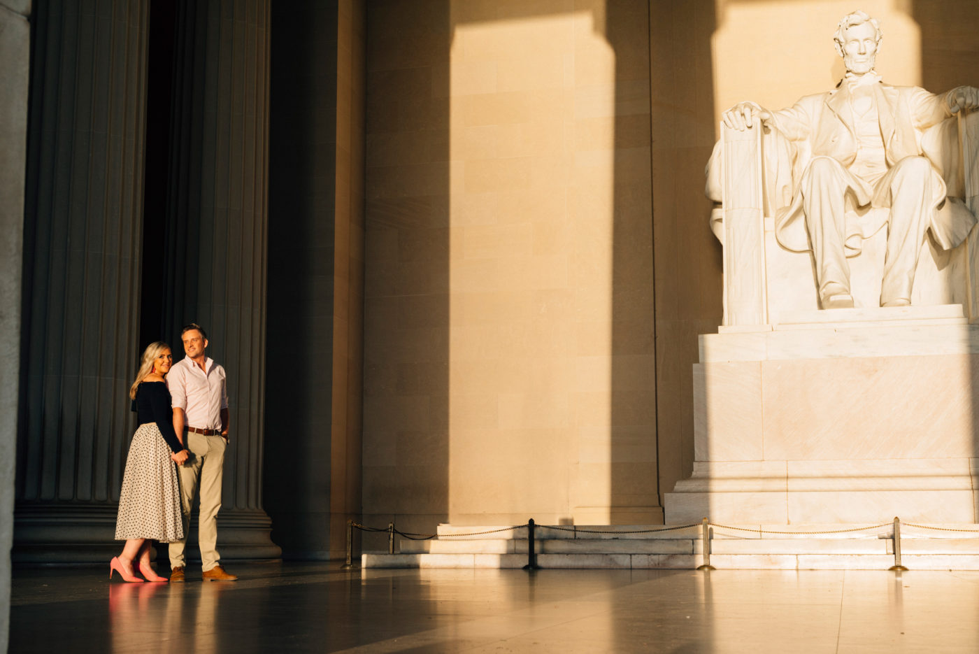 Couple pose in front of the Lincoln Memorial statue